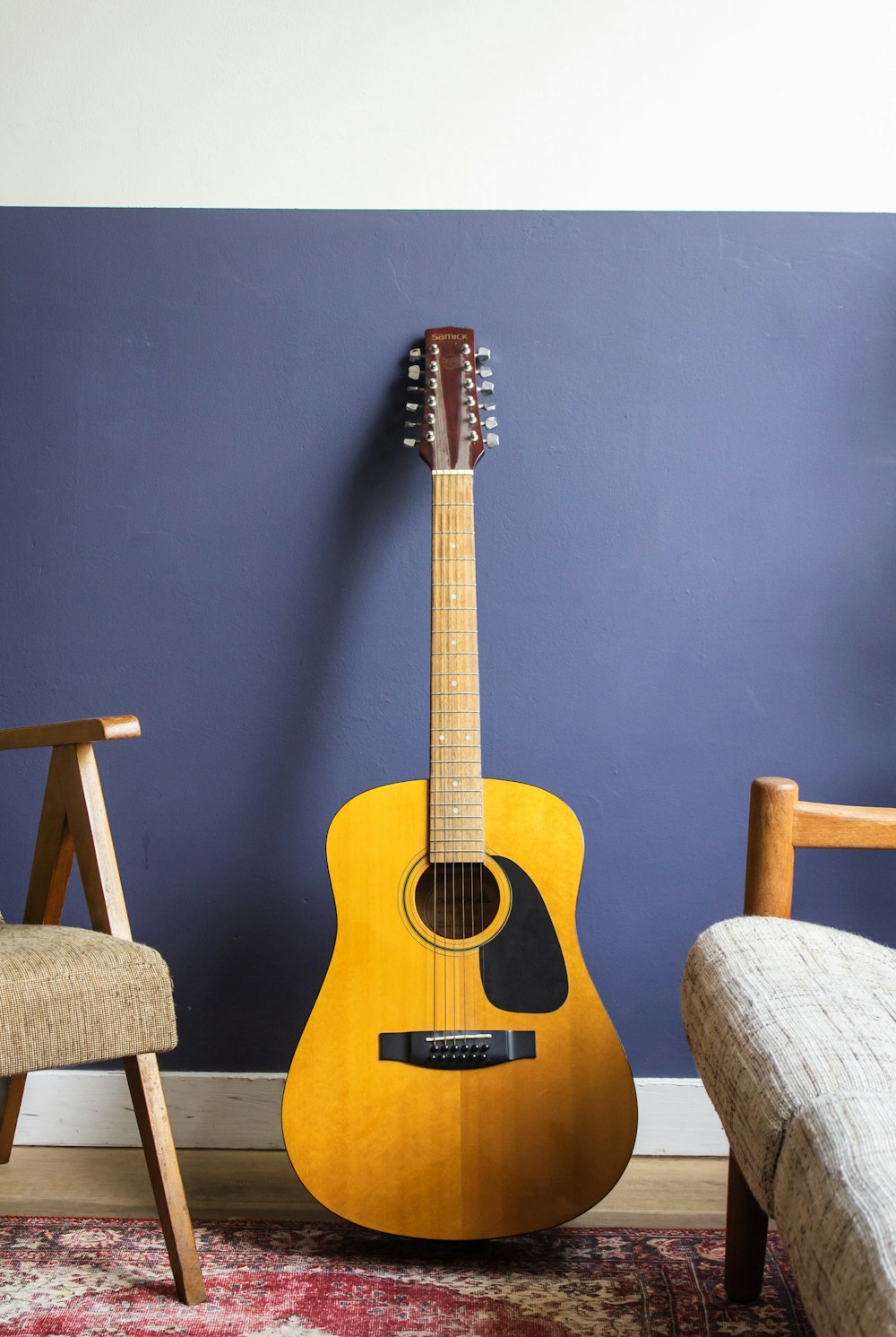 벽에 기대어 있는 노란색 어쿠스틱 기타