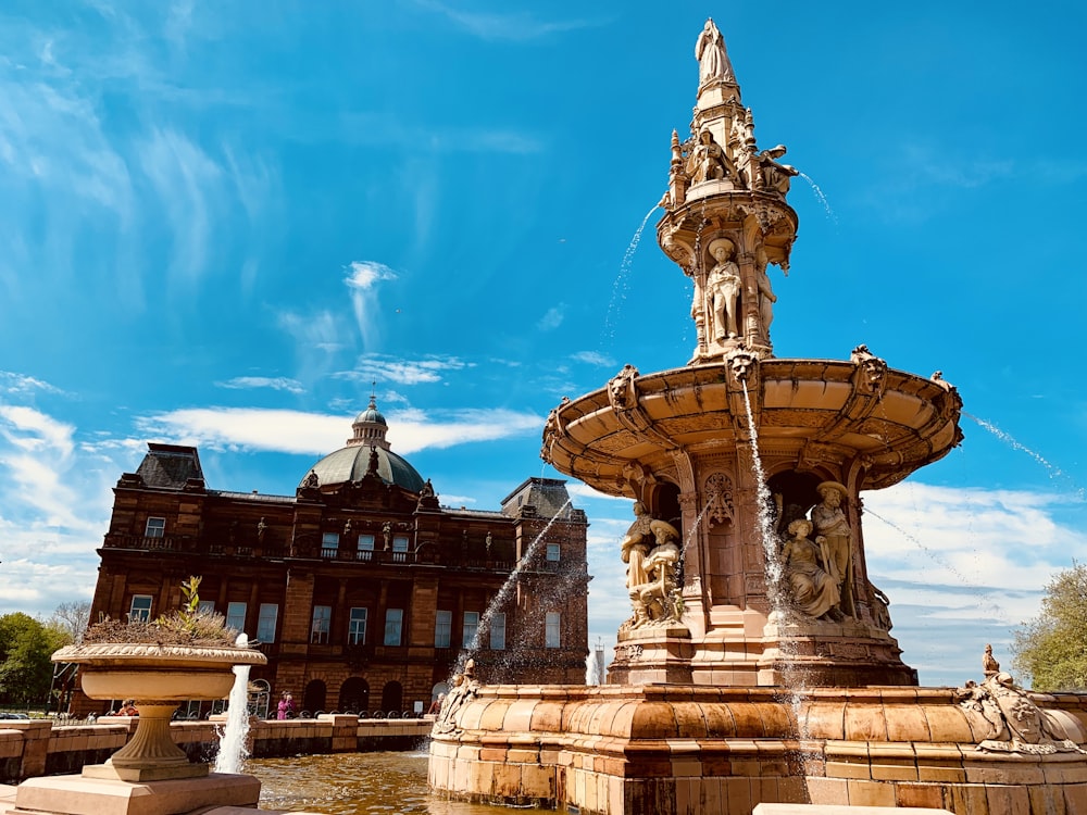 water fountain outside castle under blue sky