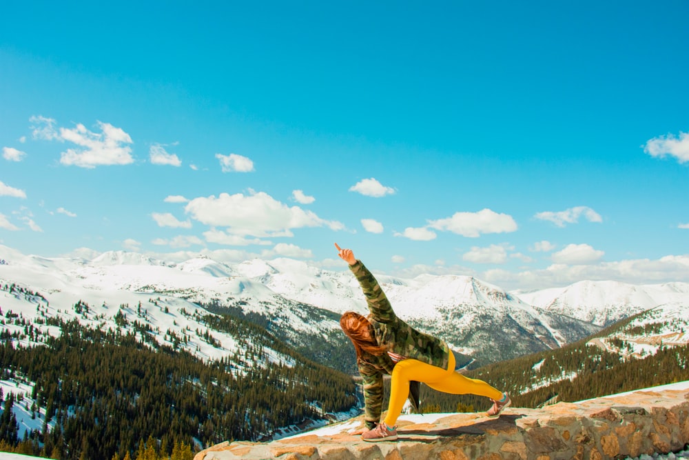 woman performing yoga on cliff