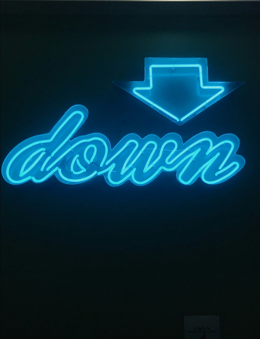a neon sign that says down with a hat on top of it