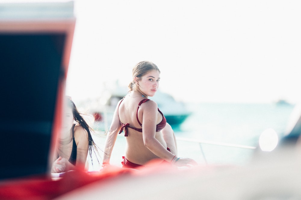 Mujer con bikini rojo mirando por encima de su hombro derecho