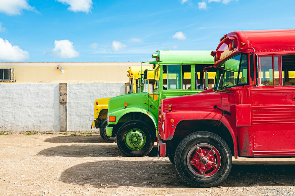 yellow, green, and red trucks parked on road at daytime