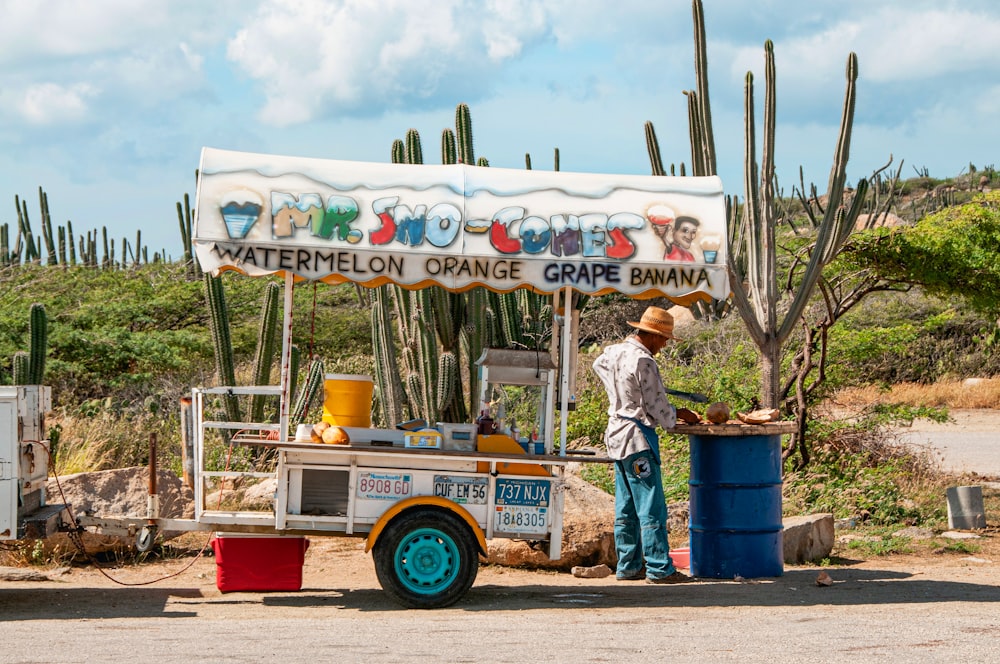 man standing beside Mr. Sno-Cones food cart