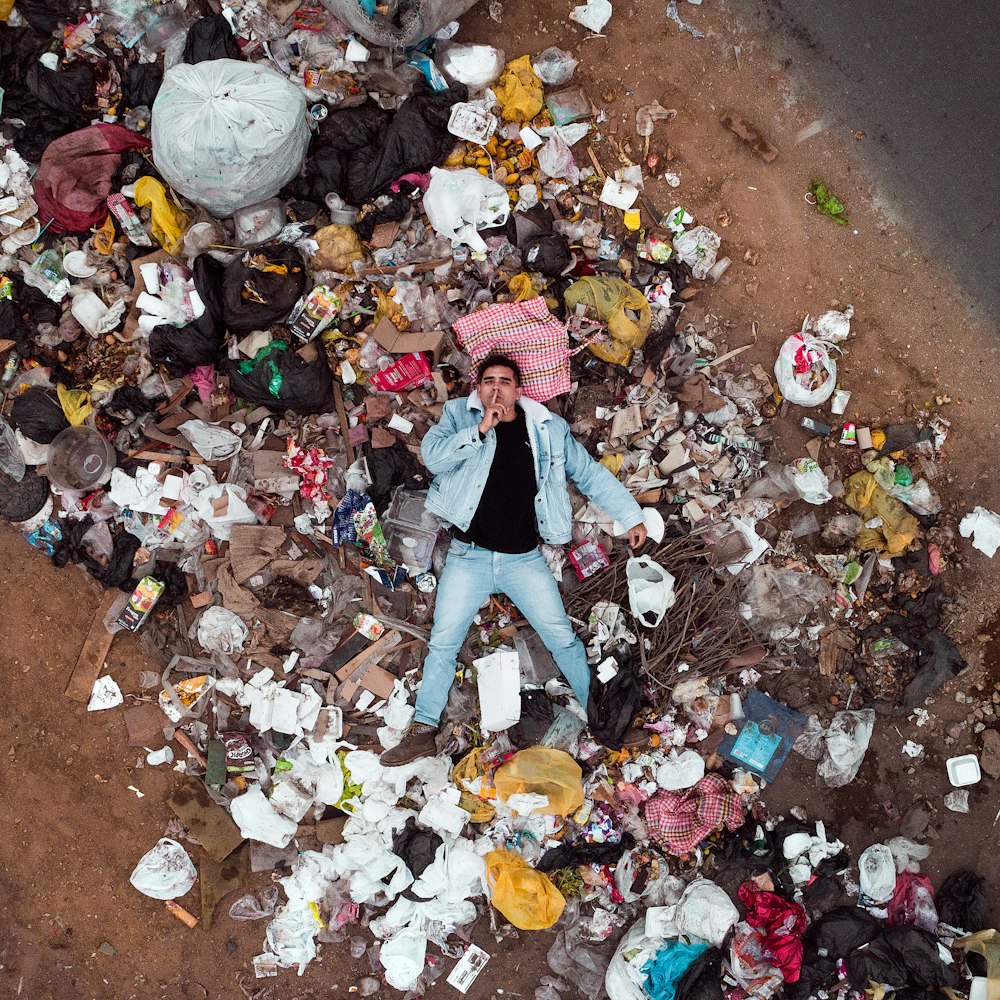 man lying on garbage pile in aerial photography