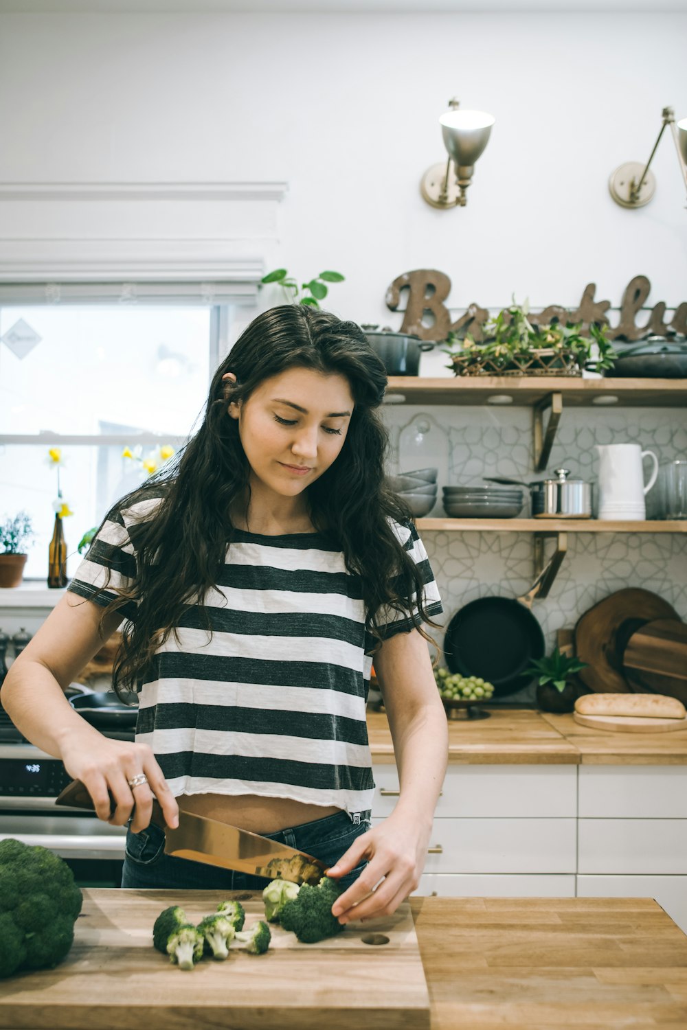 woman chopping broccoli inside kitchen