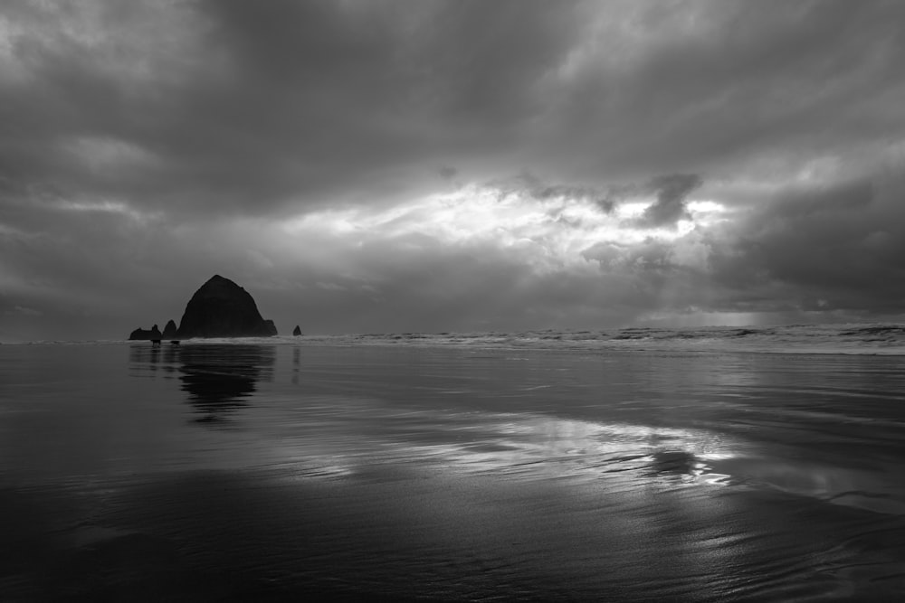 grayscale photography of island under clouds