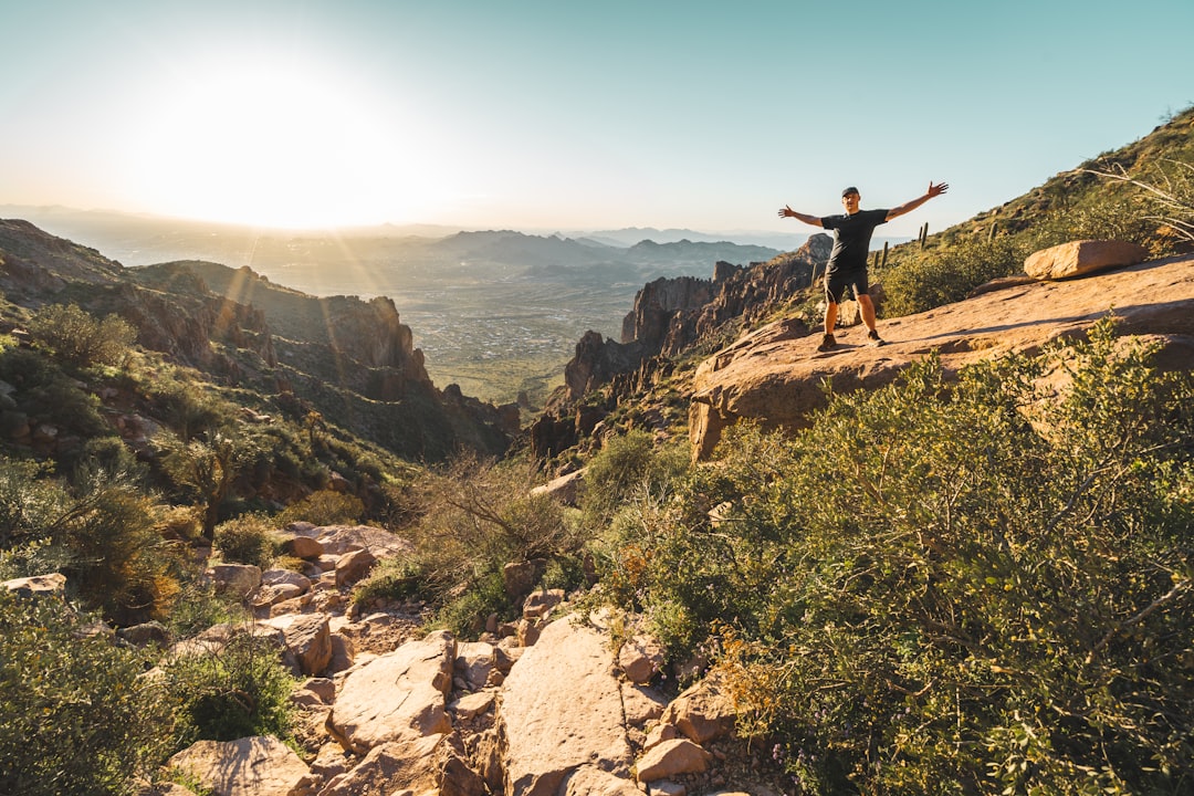 man standing on rocky mountain during day