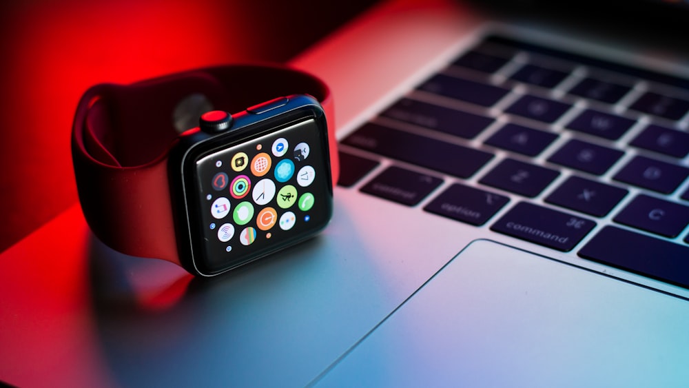 A refurbished Apple watch on top of an open refurbished Apple Macbook Air