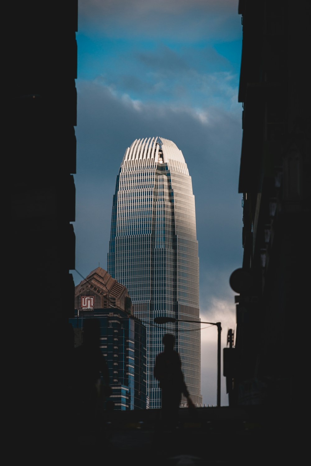 man near lamppost and high-rise building