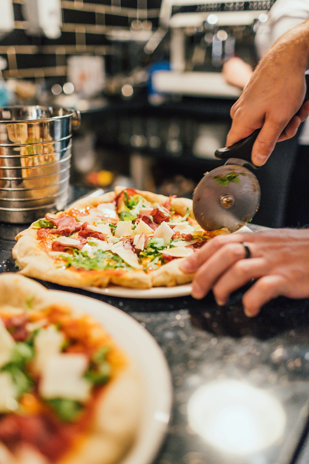 person slicing pizza