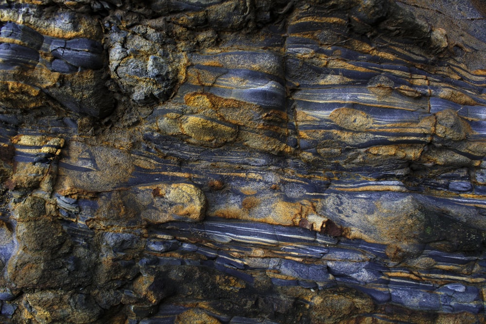a close up of a rock face with blue and yellow stripes