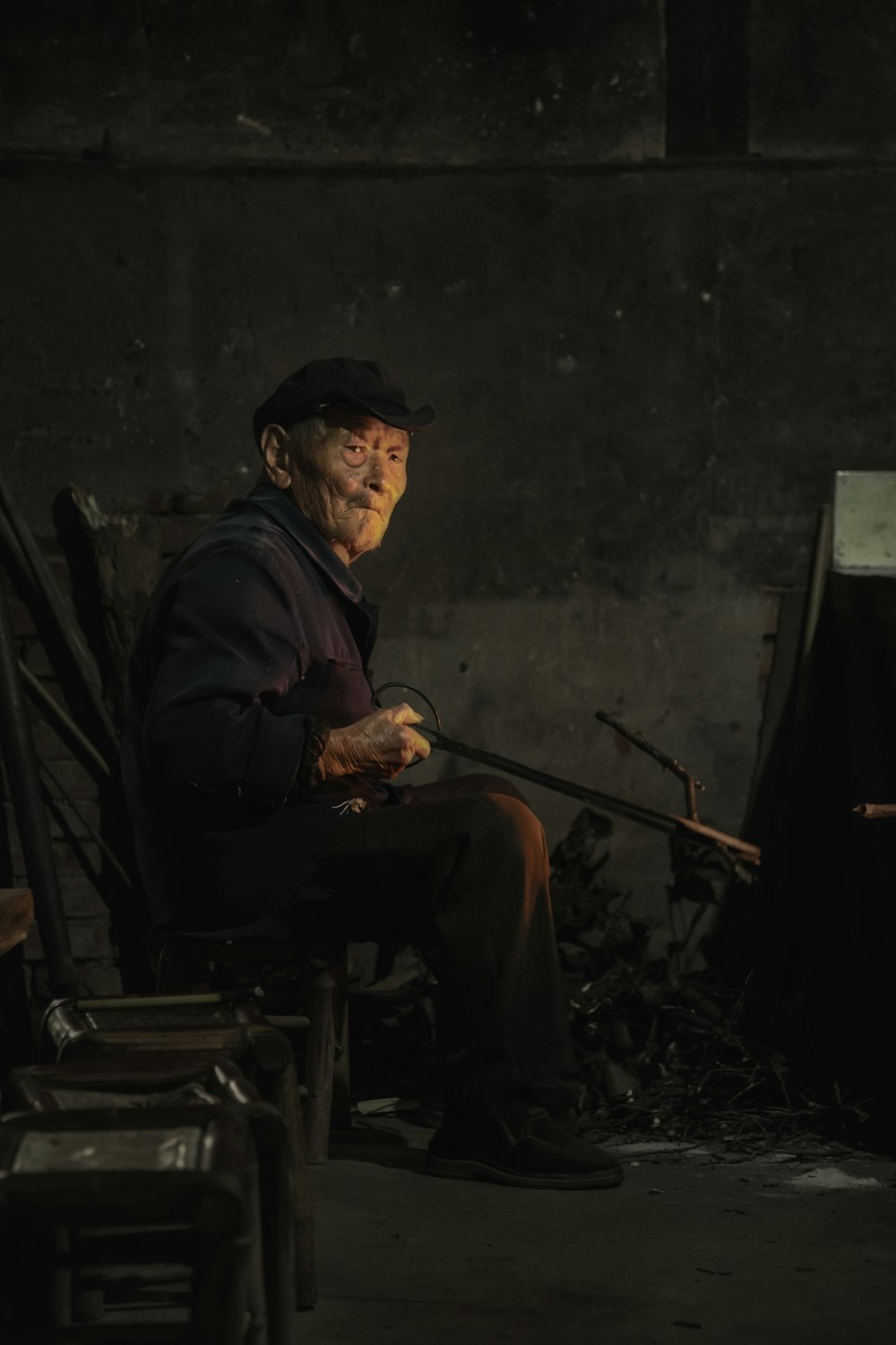 man wearing black jacket and pants sitting on chair