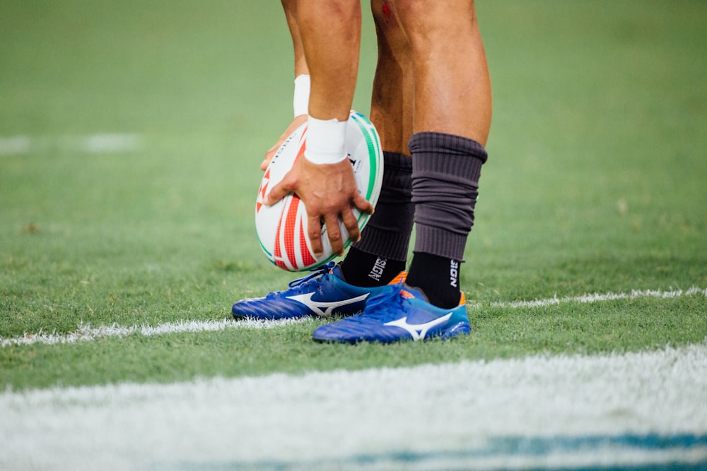 hombre sosteniendo una pelota de rugby