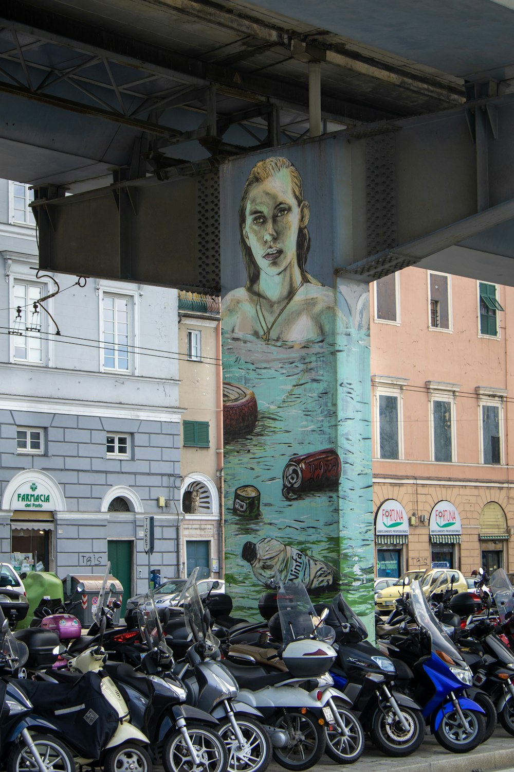 motorcycles parked under bridge