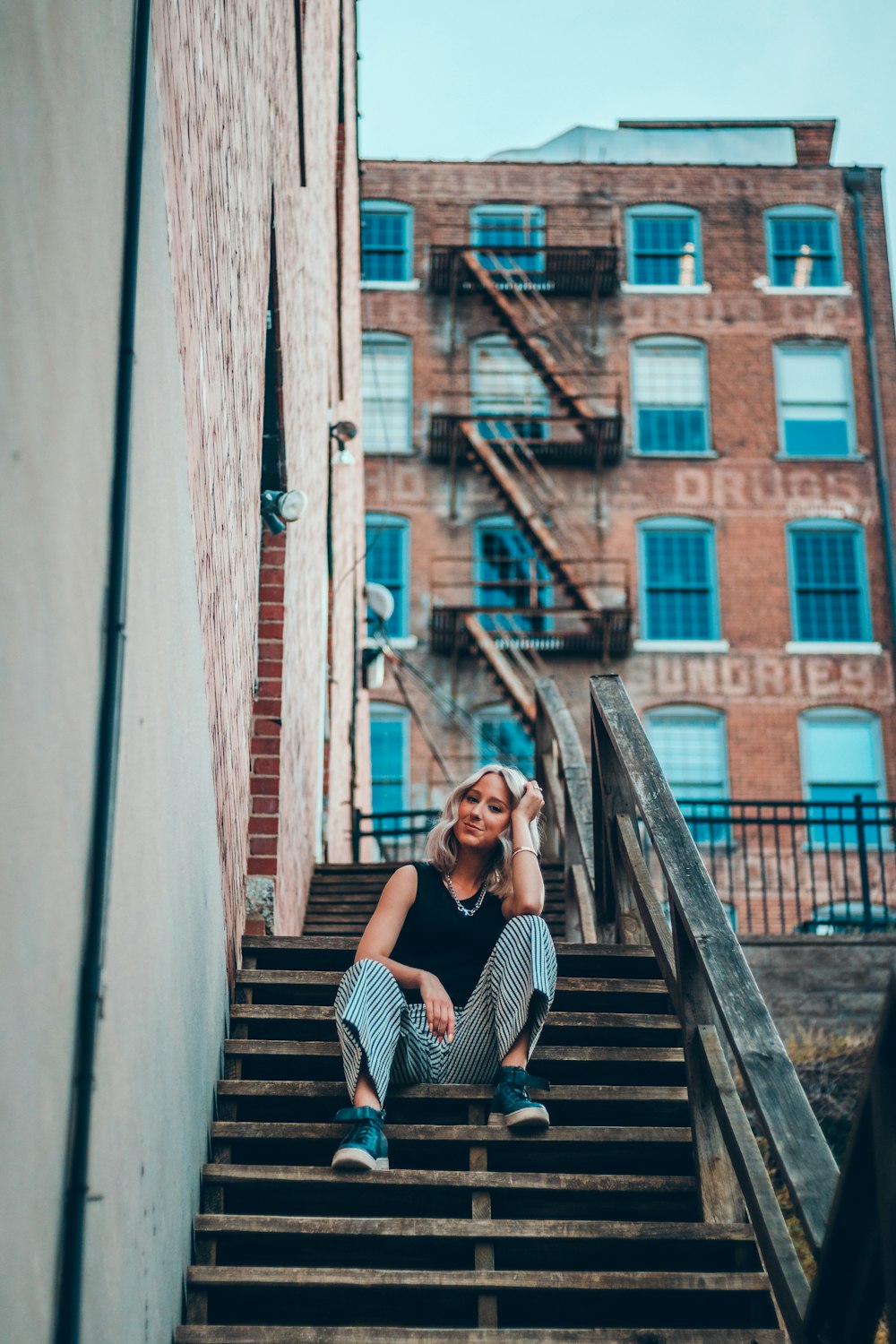 woman in black tank top sitting on stairs
