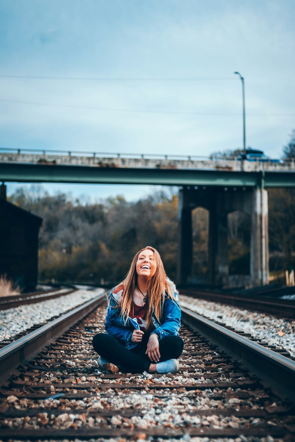 smiling woman sitting on train railway