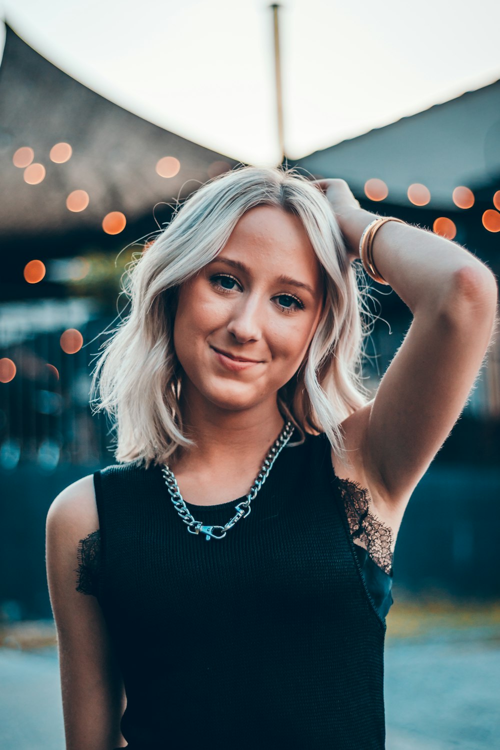 woman in black sleeveless blouse standing and smiling