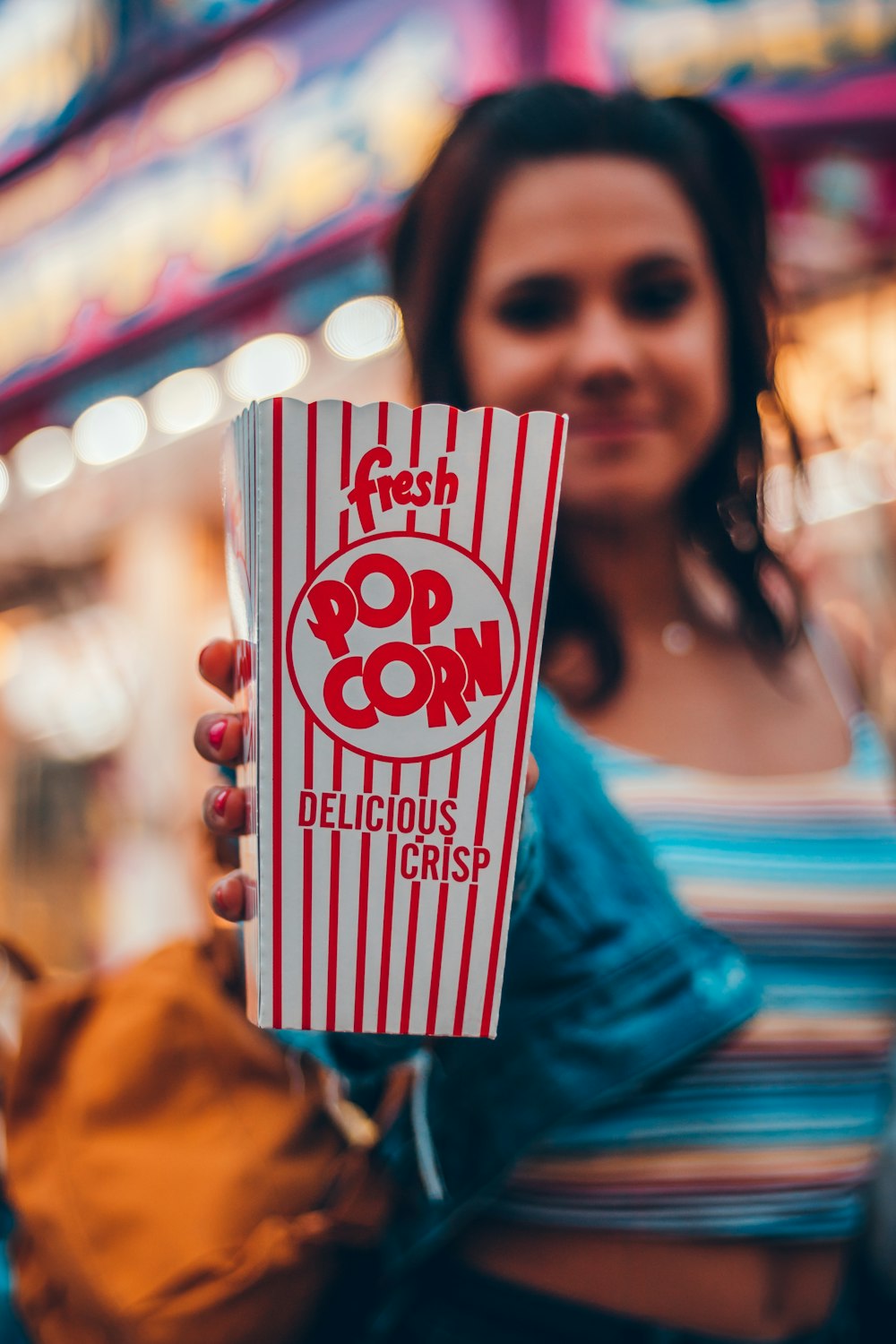 woman holding popcorn container