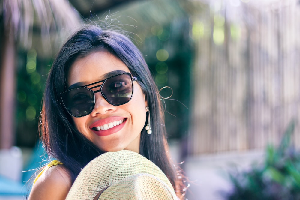 smiling woman wearing black sunglasses taking selfie
