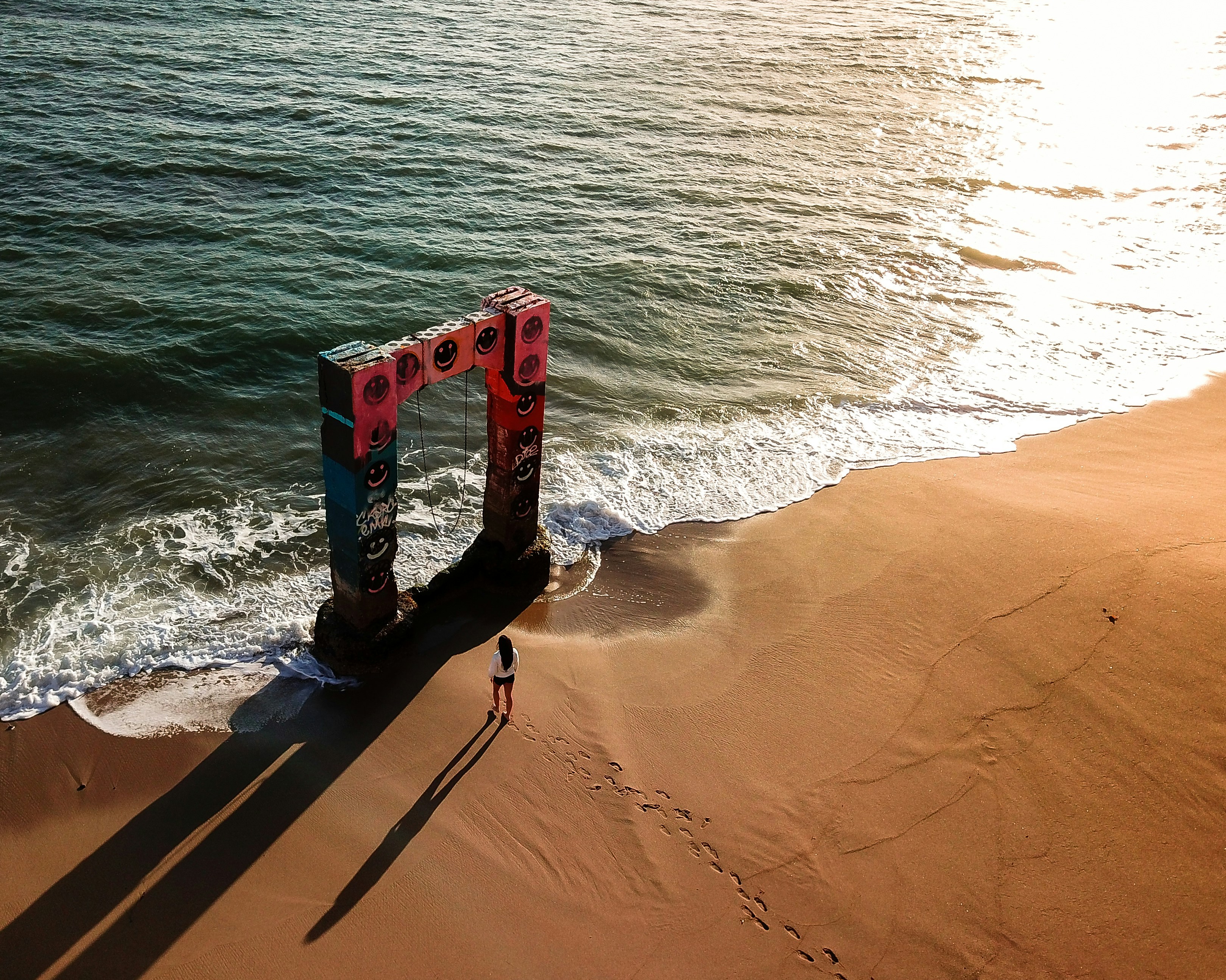 woman walking towards arch at the beach, https://www.instagram.com/francistogram/