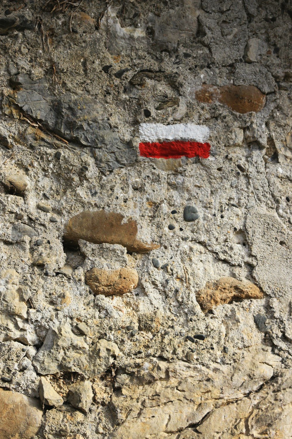 red and white striped paint on stone wall