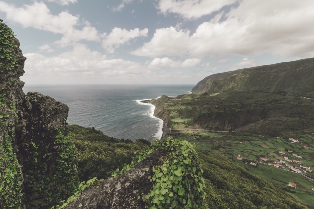 village in between cliff near ocean