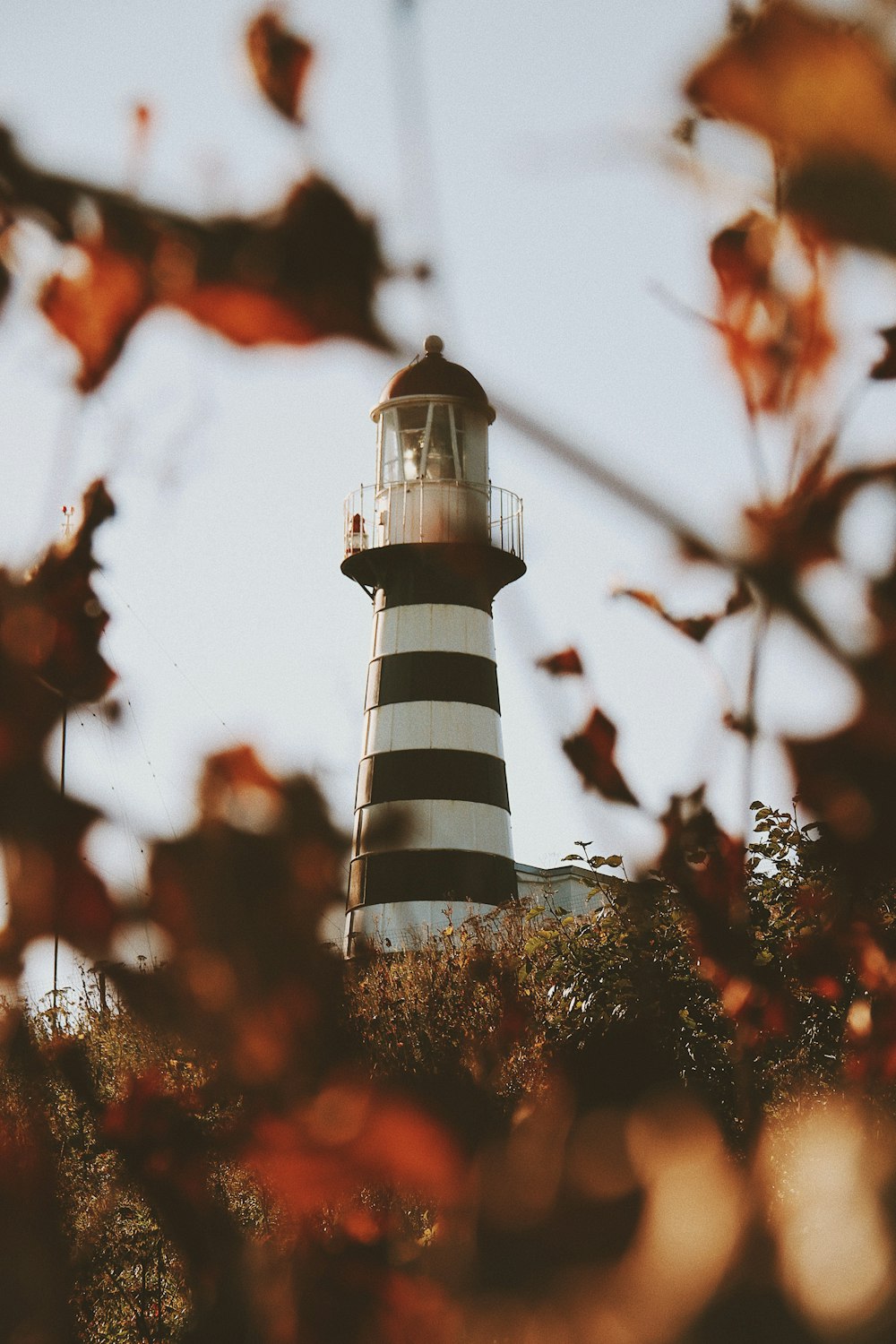 low angle photo of black and white stripe lighthouse tower during daytime
