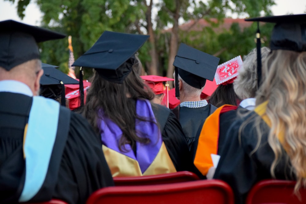 graduates sitting on chair during daytime