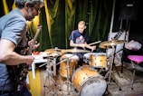man in blue t-shirt playing drum set