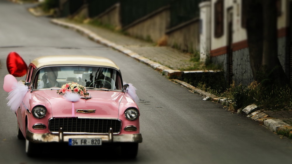 Pinkfarbenes Fahrzeug, das tagsüber auf der Straße unterwegs ist