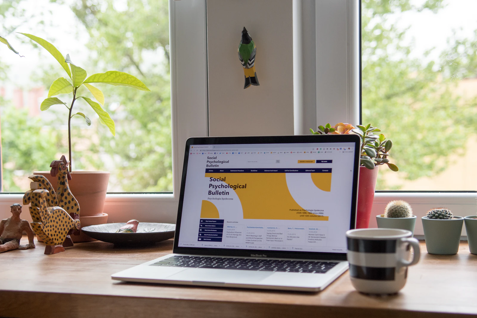 Laptop displaying a modern website design, resting on a desk with plants
