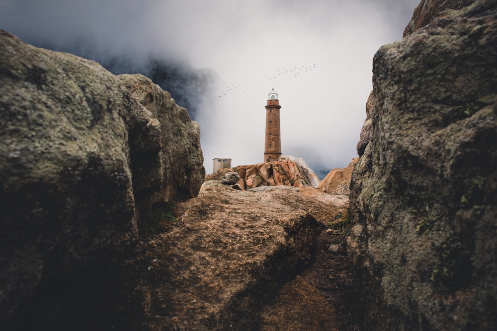 lighthouse on cliff near rock mountain