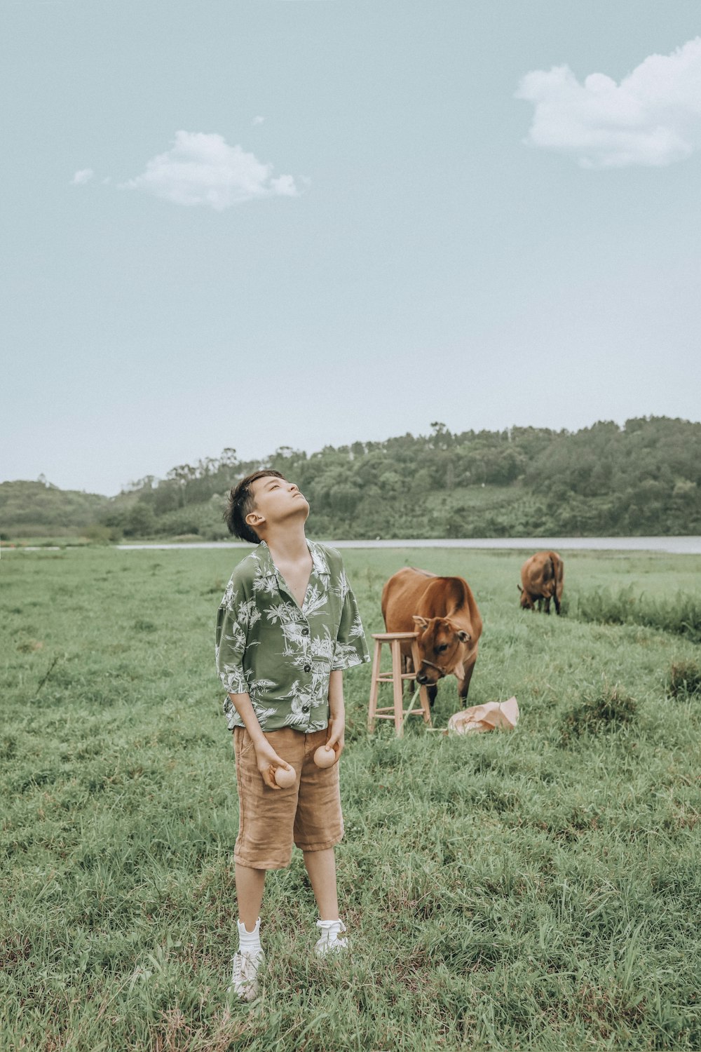 man looking up while standing on grass field