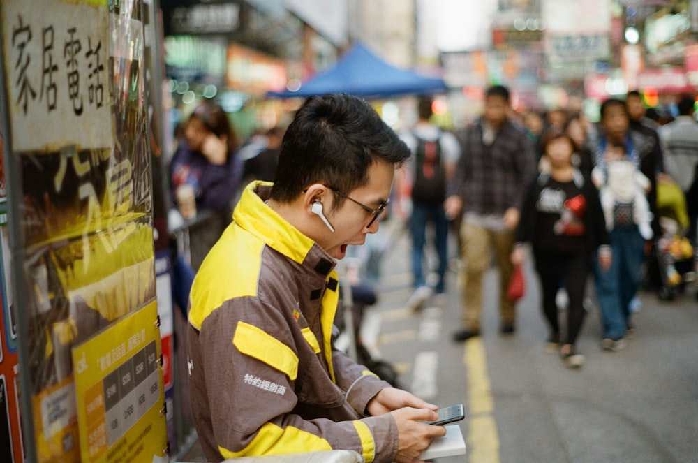 man using smartphone while yawning