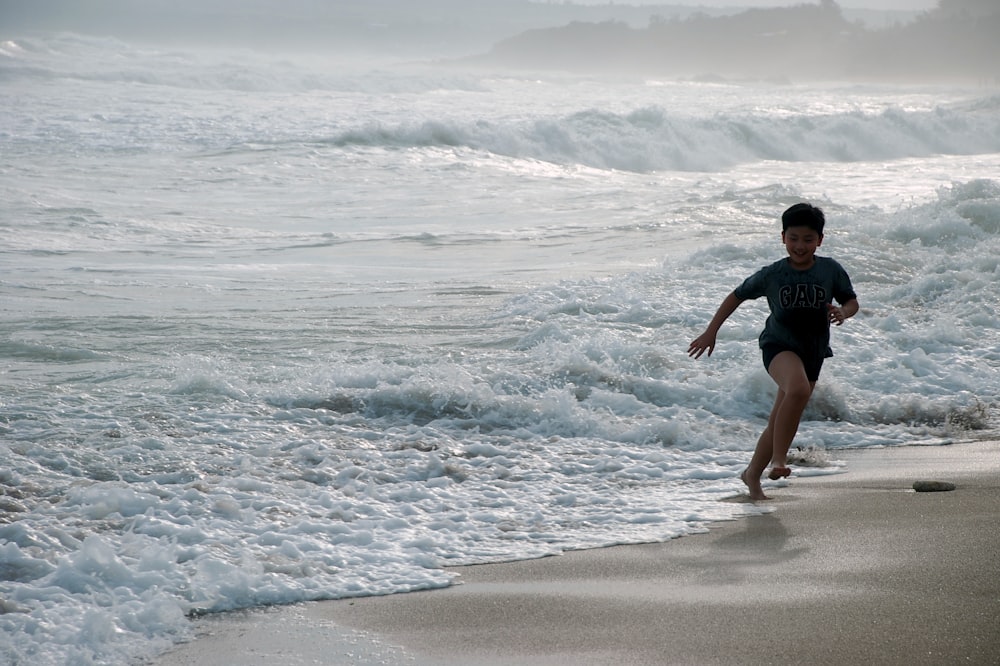 garçon courant sur la plage pendant la journée