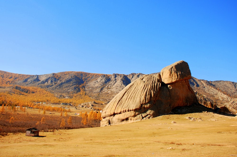 house near stone formation during daytime