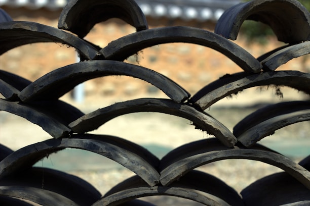 Close-up of various colorful roof tiles stacked neatly under bright sunlight.