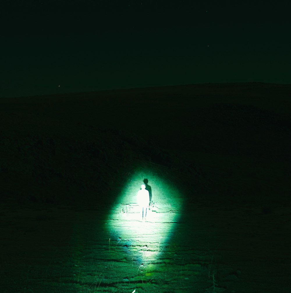 person spotting standing man using flashlight during nighttime