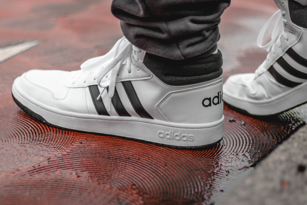 white-and-black Adidas low-top sneakers