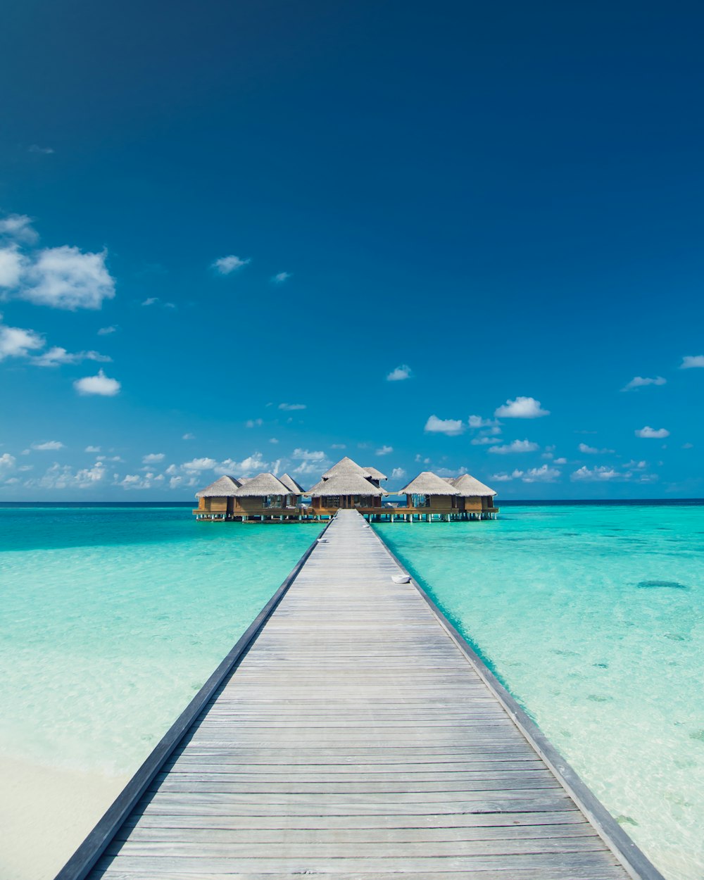 empty wooden dock on clear blue sea under clear blue sky during daytime