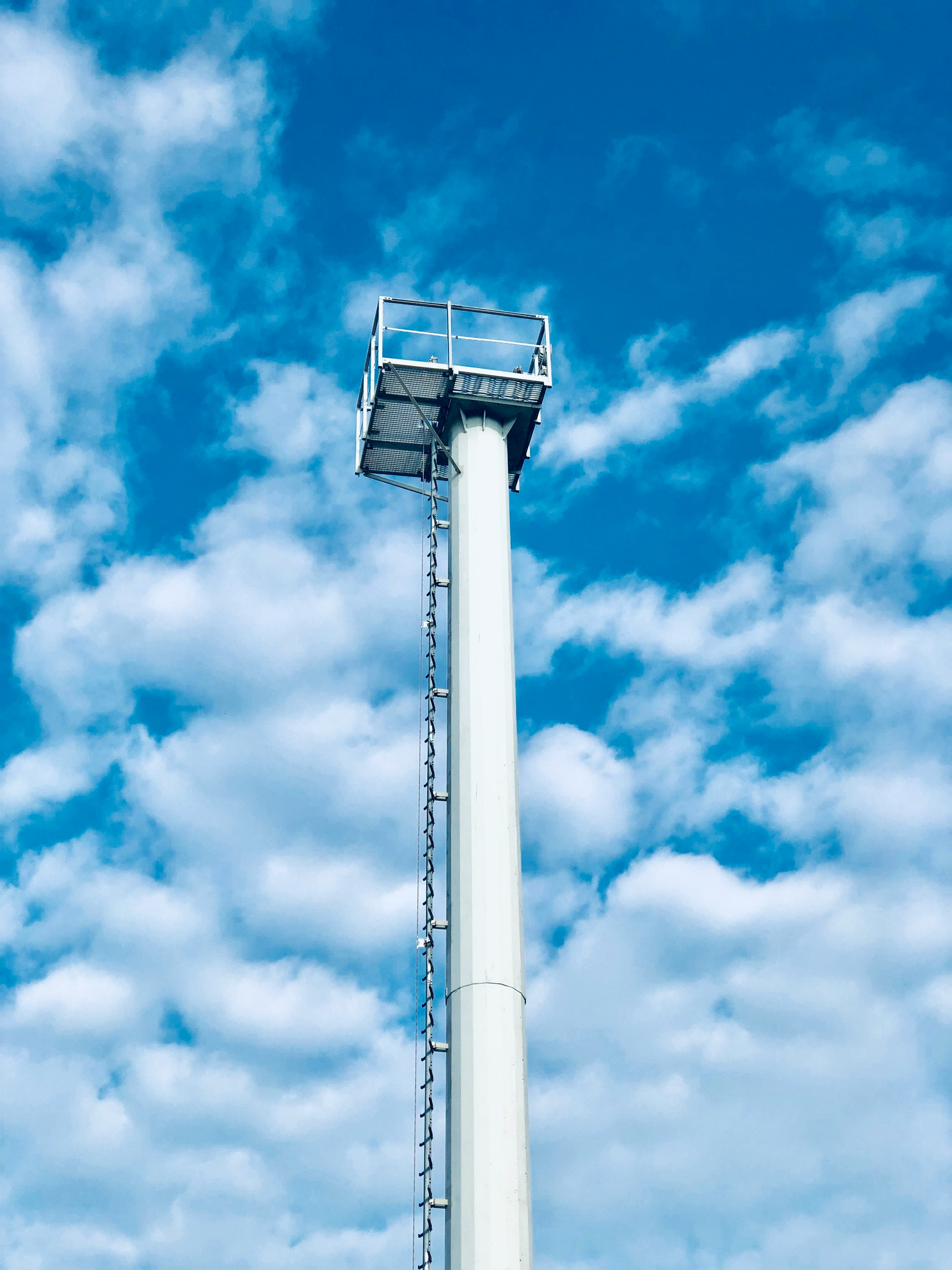 white concrete tower under blue sky and white clouds during daytime