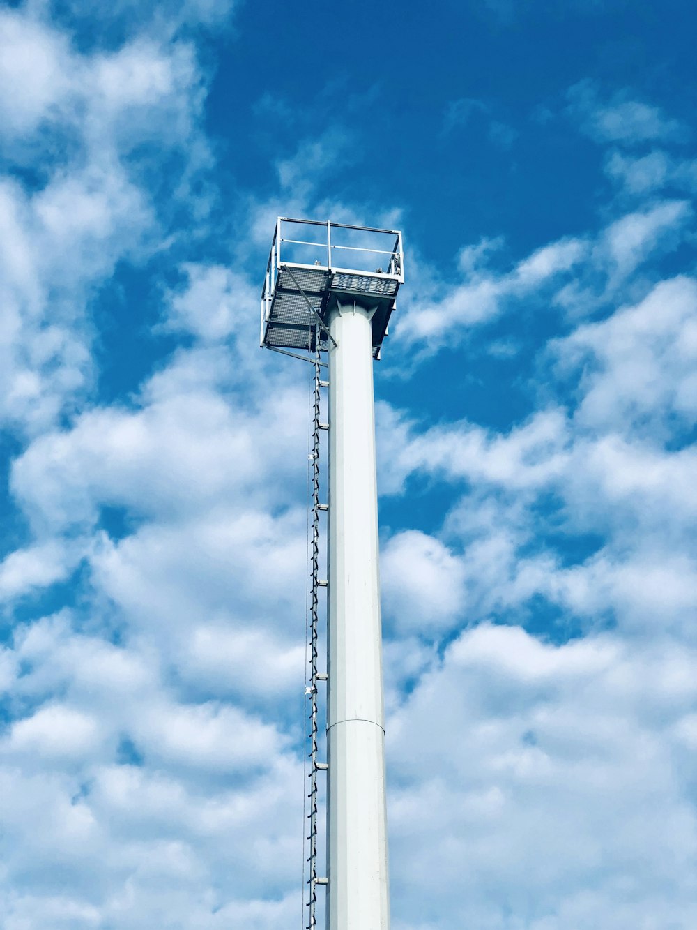 white concrete tower under blue sky and white clouds during daytime