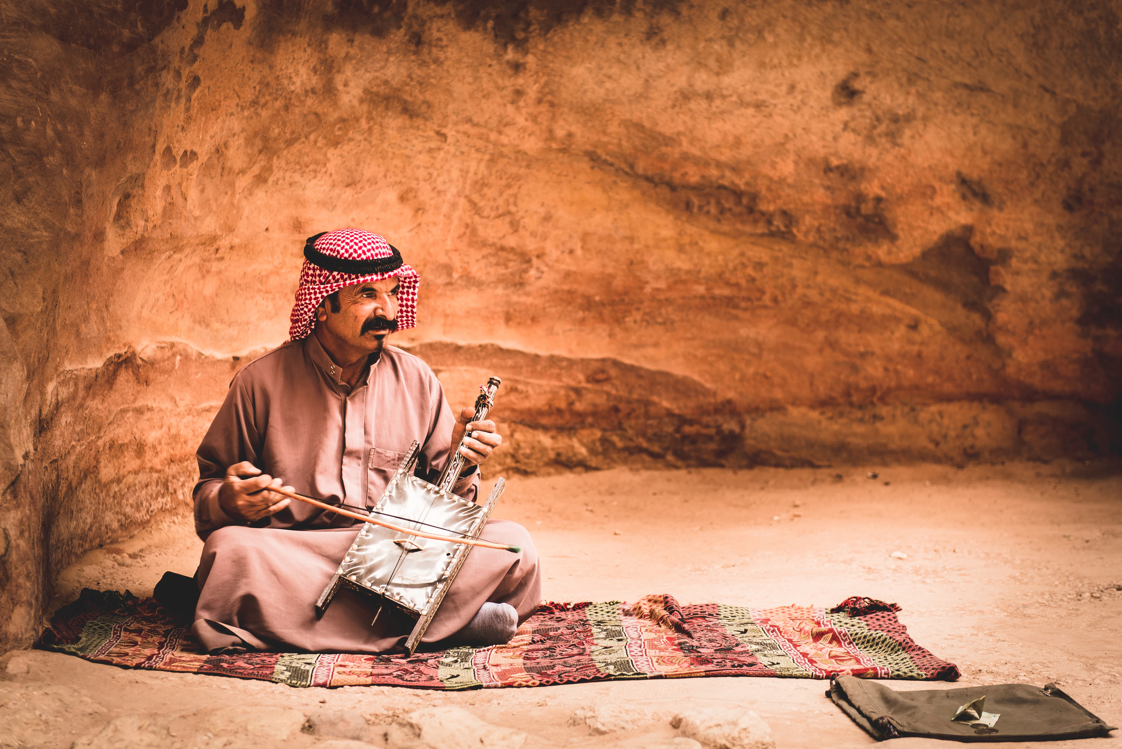 A Bedouin musician playing a rababa in a canyon at Wadi Rum