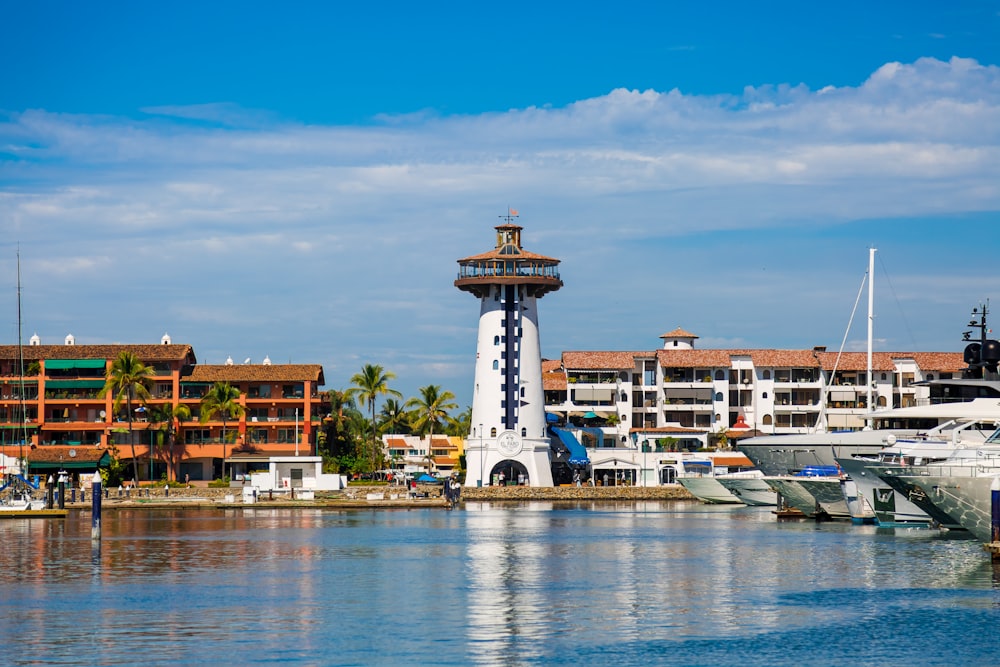 white and brown lighthouse in dock with boats