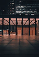 Night shot of a modern office building lit with warm interior lights.