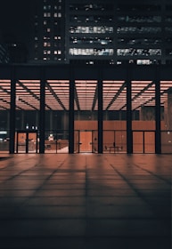 Evening shot of a completed commercial building illuminated with warm lights.
