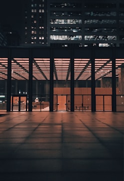 Night view of a newly constructed modern office building lit warmly.