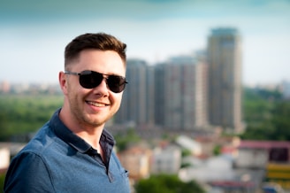 man wearing blue polo shirt with building background