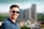 man wearing blue polo shirt with building background