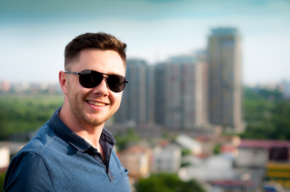 homem vestindo camisa polo azul com fundo do edifício